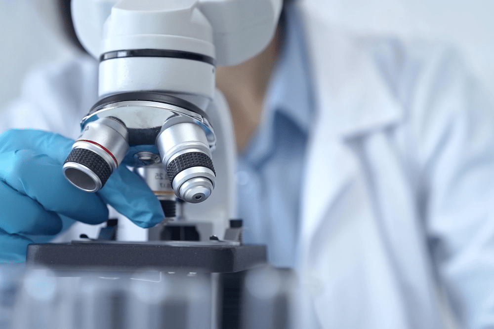 A scientist adjusting a modern microscope in a laboratory during scientific research.